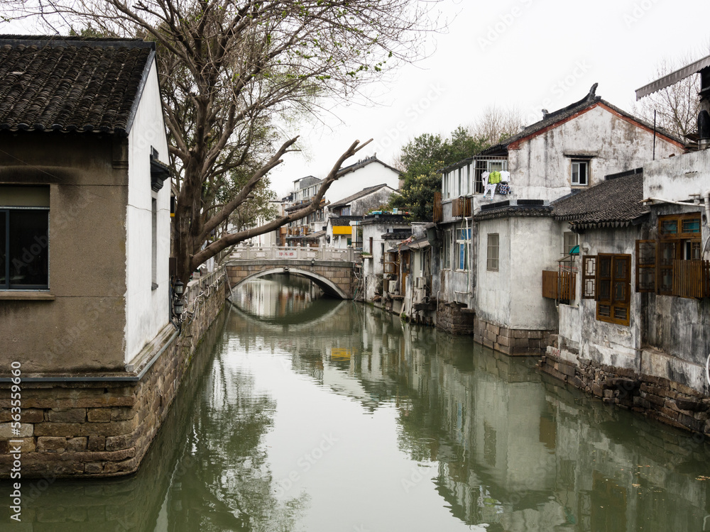 Water canal in Suzhou old town lined with white walled houses