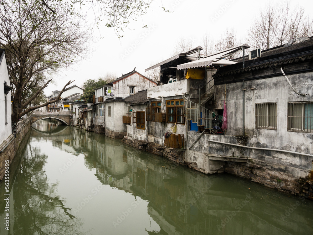 Water canal in Suzhou old town lined with white walled houses