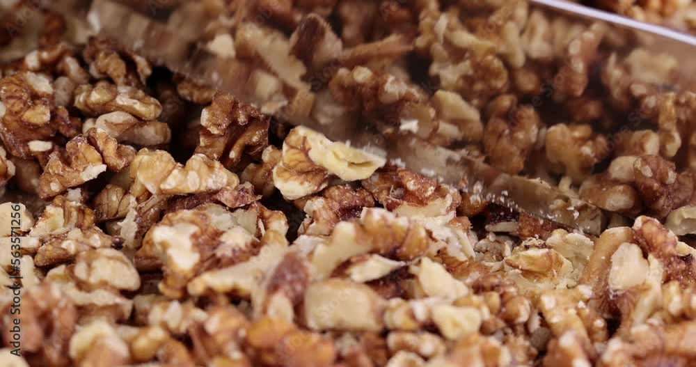 Cut walnuts on a board, cut ripe walnuts into pieces for use in confectionery Cut walnuts on a board, cut ripe walnuts into pieces for use in confectionery