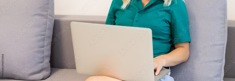 A young smiling woman wearing red Santa Claus hat making video call on social network with family and friends on Christmas day