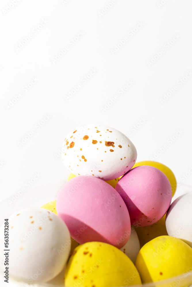 Colorful chocolate Easter eggs on white background with copy space