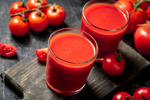 Tomato juice in a glass on a cutting board. 