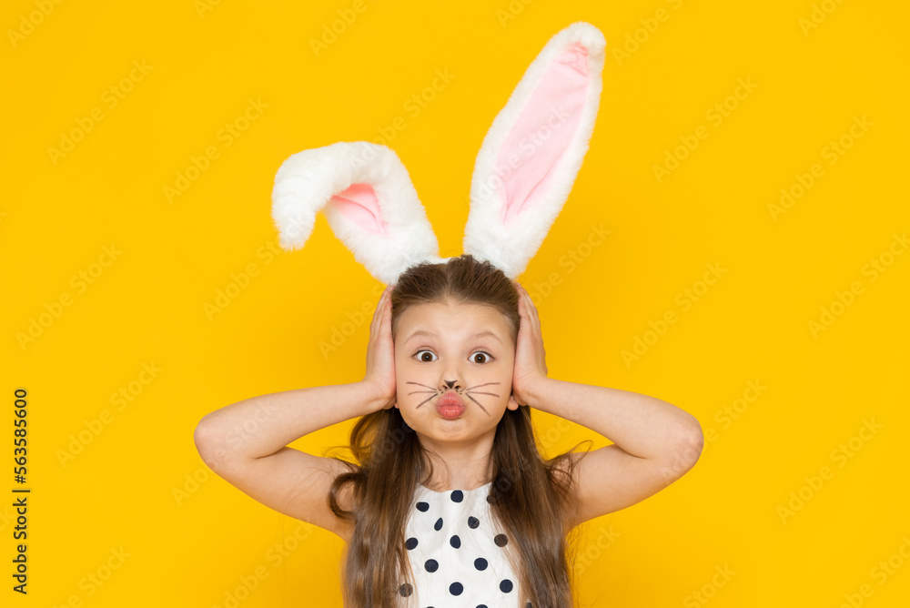 A girl with Easter bunny ears puffed out her cheeks and clutched her head with her hands.