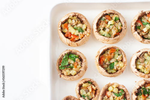 Stuffed mushrooms with vegetables on a baking dish.
