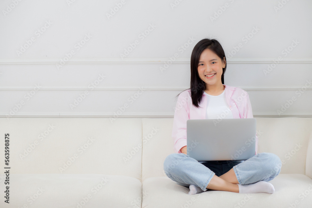 Young asian business woman work from home with laptop computer online to internet on sofa in living room, freelance girl using notebook sitting on couch with comfort and relax, lifestyles concept. Young asian business woman work from home with laptop computer online to internet on sofa in living room, freelance girl using notebook sitting on couch with comfort and relax, lifestyles concept.