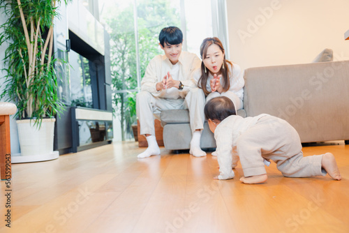 ハイハイをする赤ちゃんと子供の成長を見守る両親