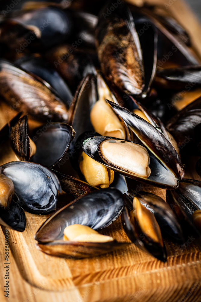 Delicious boiled mussels on a wooden cutting board. Delicious boiled mussels on a wooden cutting board.