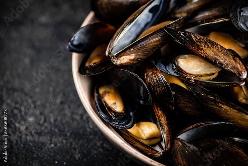 Boiled mussels in a bowl on the table. 