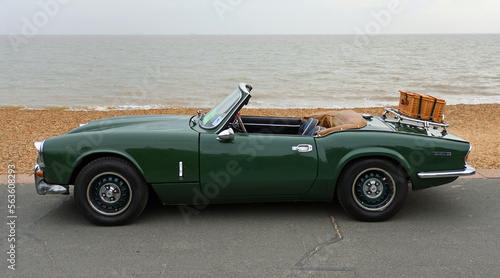 Photo Classic Green Spitfire Mk 4  motor  car with picnic basket on boot parked on Seafront Promenade beach and sea in background