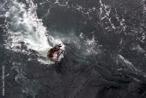 The fishing net with a catch rises to the trawler