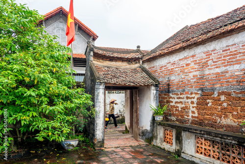 Tableau sur toile Vietnam,  woman with bicycle walking in the street of the ancient village of Duong Lam