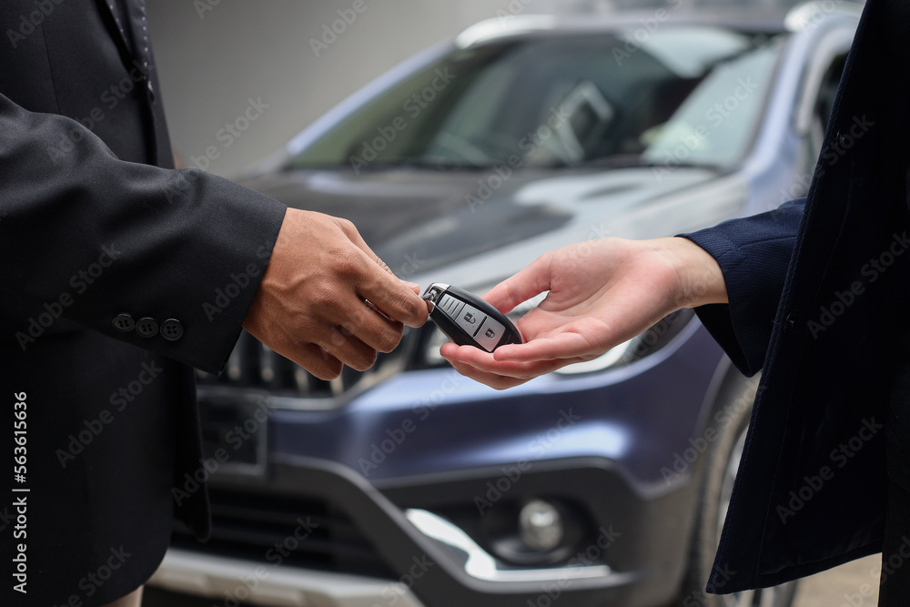 Close-up image of hands of client buys a car and receives keys from the car dealer sales. Close-up image of hands of client buys a car and receives keys from the car dealer sales.