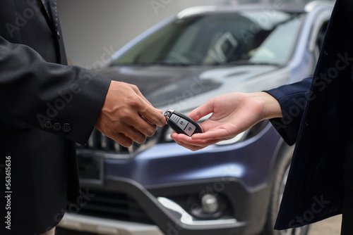 Close-up image of hands of client buys a car and receives keys from the car dealer sales. © Queenmoonlite Studio
