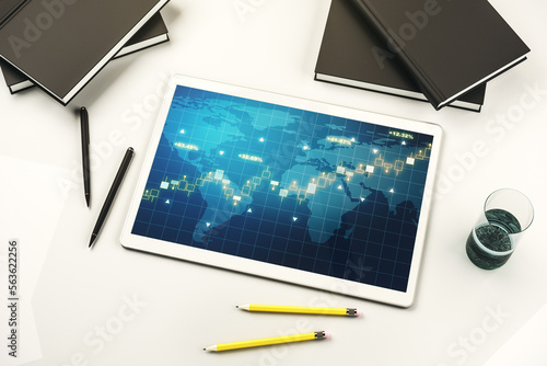Modern digital tablet display with abstract creative financial graph and world map, financial and trading concept. Top view. 3D Rendering