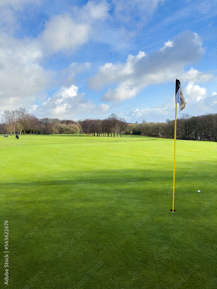Flag and the hole at golf club blue sky summers day with some clouds. Flag and the hole at golf club blue sky summers day with some clouds.