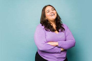 Hispanic plus size woman laughing and smiling in a studio