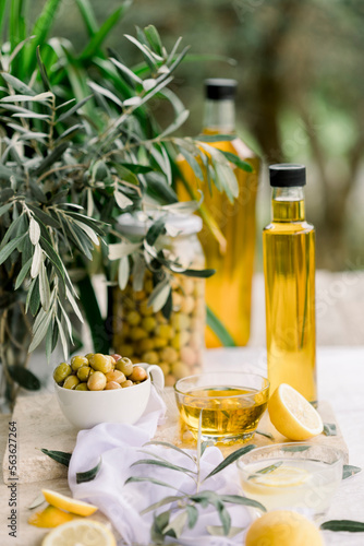 Various olives flavored with spices in white cup and glass jar. Green olives, black olives. Front and top shot on a white background