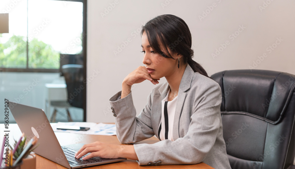 Beautiful Asian Manager attractive mature businesswoman working on laptop in her workstation. Beautiful Asian Manager attractive mature businesswoman working on laptop in her workstation.