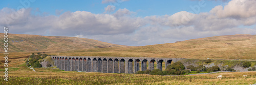 Panoramic view of Ribblehead Viaduct on a bright afternoon with clouds in sky. Yorkshire Dales National Park, UK.