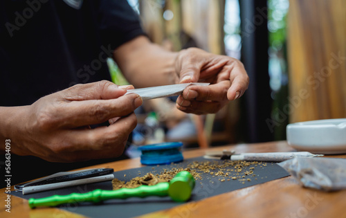 Young man making cigarettes with medical marijuana