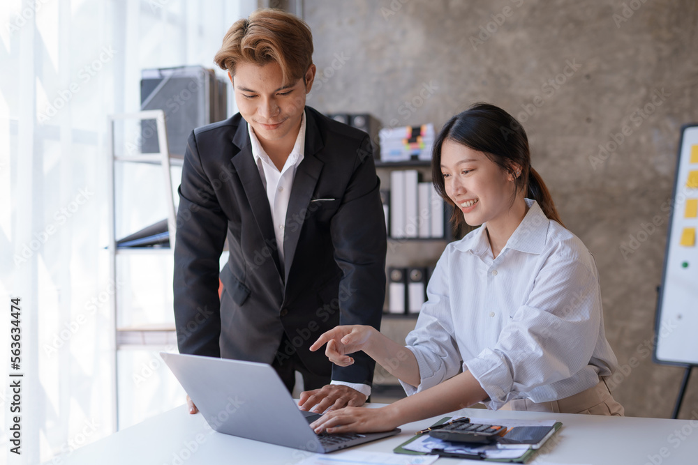 Obraz premium Two Asian business people are consulting on marketing planning, a new corporate sales strategy in line with current events.
