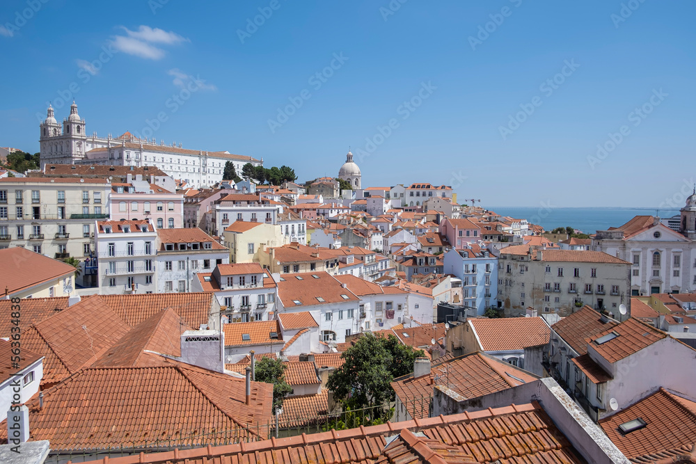 view of the Alfama district of Lisbon, from the viewpoint of Portas do Sol,  monastery of Sao Vicente de Fora and the dome of the national pantheon, with the Tajo river in the background