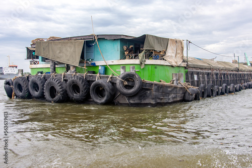 The back of a riverboat being towed on the Chao Phraya River, Bangkok, Thailand photo