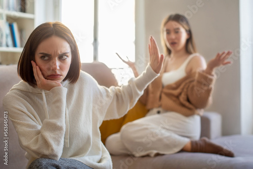 Bild auf Leinwand Sad european young woman making stop gesture with hand, ignores angry screaming