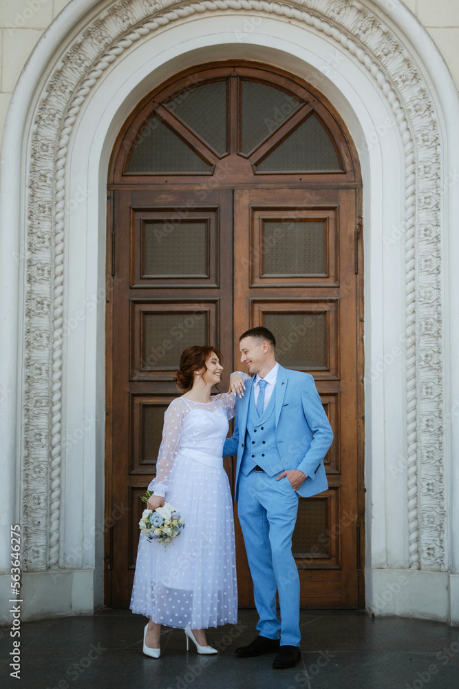 bride in a light wedding dress to the groom in a blue suit