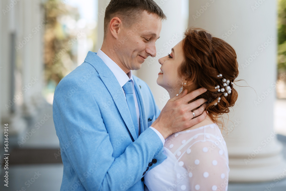 bride in a light wedding dress to the groom in a blue suit
