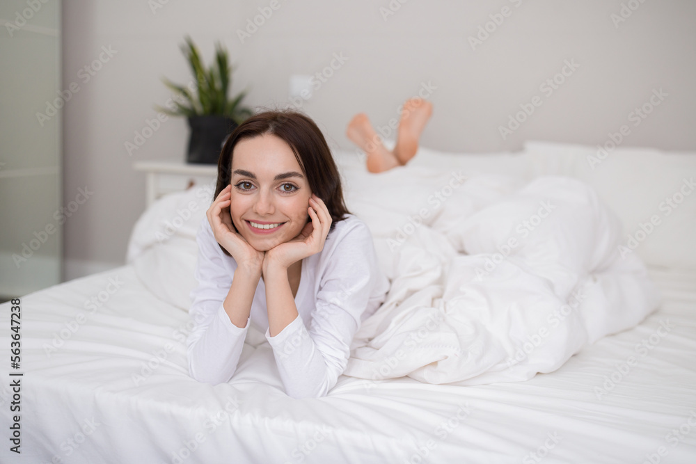 Cheerful young brunette woman enjoying happy morning, posing in bed Cheerful young brunette woman enjoying happy morning, posing in bed