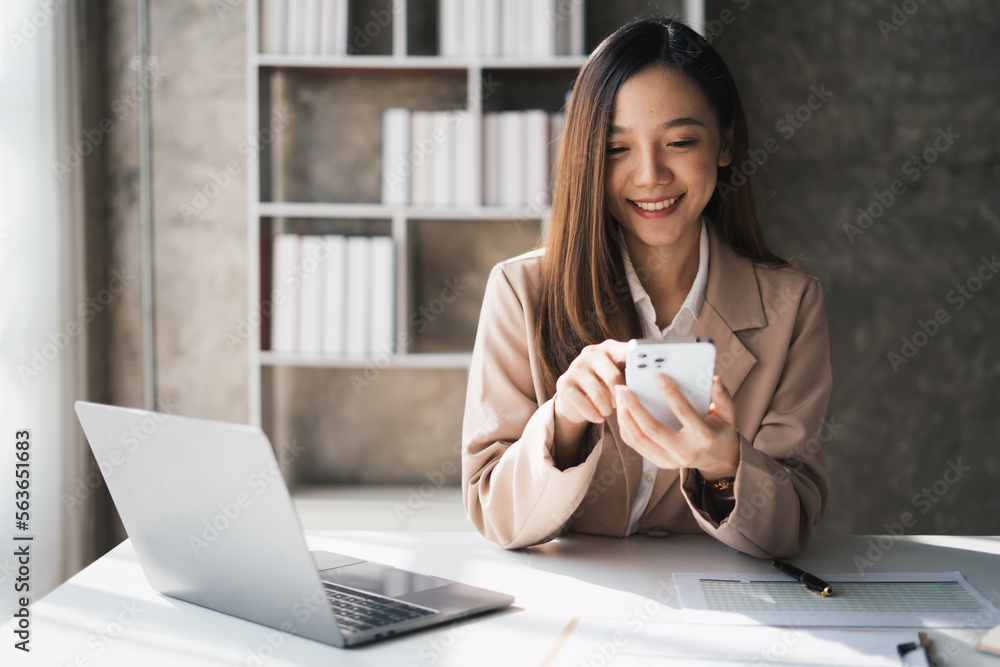 Cheerful young chinese business woman talking on phone working in modern office. Cheerful young chinese business woman talking on phone working in modern office.