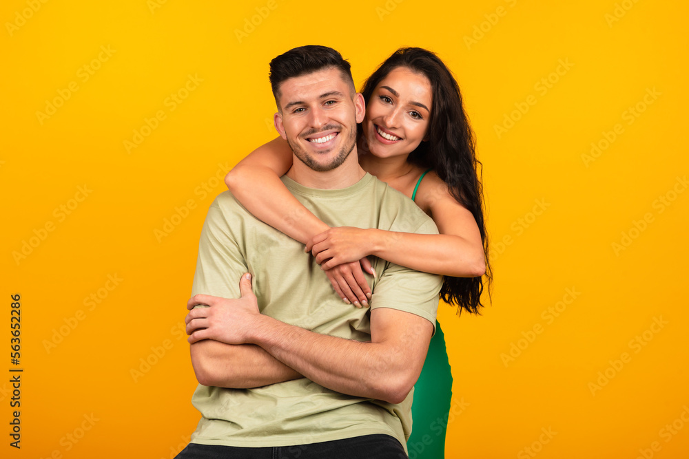 Happy young middle eastern lady in green dress hugging boyfriend, celebrate party event Happy young middle eastern lady in green dress hugging boyfriend, celebrate party event