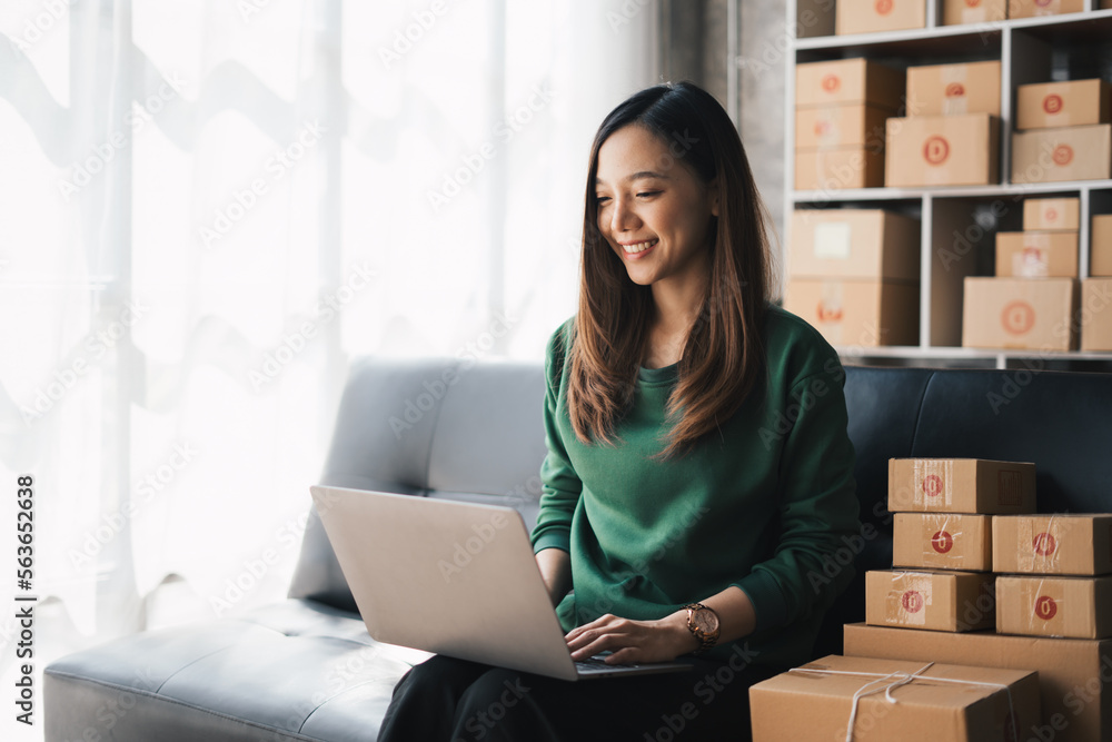 Start up small business, SME female owner checking order online to prepare to pack a box of goods for sale to customers, sme business idea. Start up small business, SME female owner checking order online to prepare to pack a box of goods for sale to customers, sme business idea.