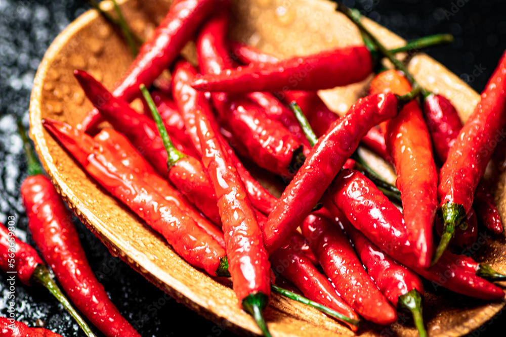 Chili peppers on a wooden plate. Chili peppers on a wooden plate.