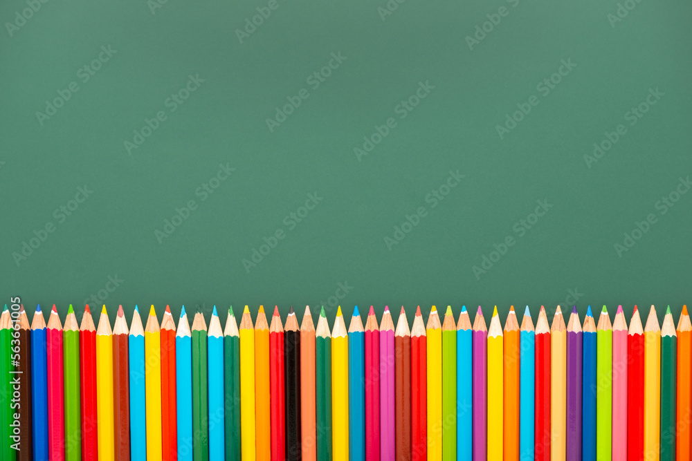 multicolored pencils is on green chalkboard background, top view, copy space, back to school concept multicolored pencils is on green chalkboard background, top view, copy space, back to school concept
