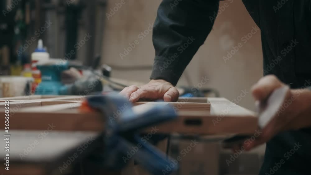 Carpenter sanding wood with sandpaper. Male hands polishing wood with sandpaper. Carpentry, craftsmanship, Handicrafts Carpenter sanding wood with sandpaper. Male hands polishing wood with sandpaper. Carpentry, craftsmanship, Handicrafts