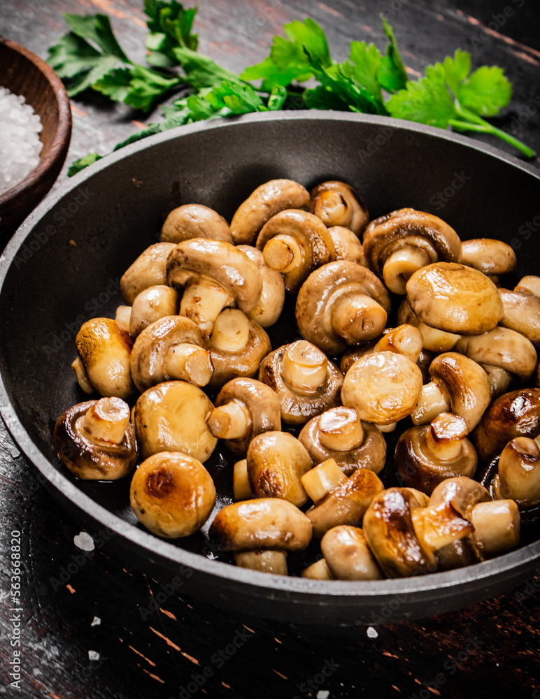Frying pan with fried small mushrooms with parsley. Frying pan with fried small mushrooms with parsley.