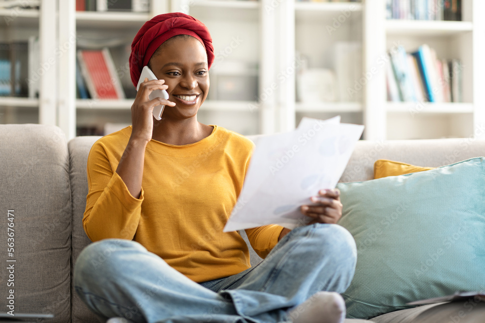 Obraz premium African american woman working from home, having phone conversation