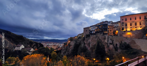 Landscape at night of the city of Cuenca, in Spain, built on the rocks, with a gray cloudy sky in the background - touristic postcard