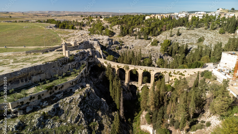 Canyon of Gravina with the old aqueduct stone bridge. Apulia region, Italy