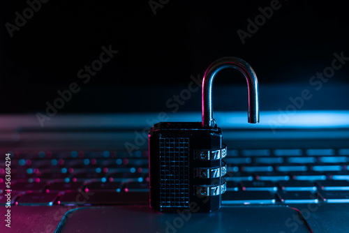 Lock on laptop as computer protection and cyber safety concept on neon background. Private data protection from hacker malware