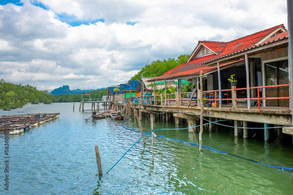 View of a fishing village in Thailand. Village on the water, cottages on stilts. Sea Gypsies in Phang Nga Bay. An exotic tourist destination with an unusual infrastructure. View of a fishing village in Thailand. Village on the water, cottages on stilts. Sea Gypsies in Phang Nga Bay. An exotic tourist destination with an unusual infrastructure.