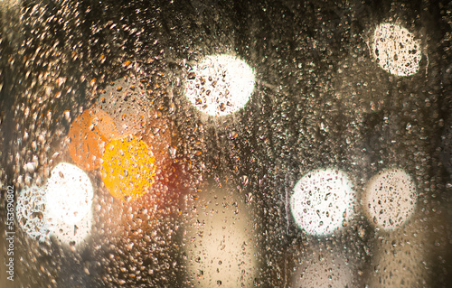 Blurred multi-colored lights of cars and a night city through a glass splashed with rain 7