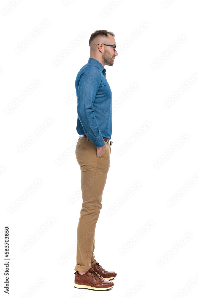 Fototapeta premium handsome man in denim shirt holding hands in pockets and waiting in line