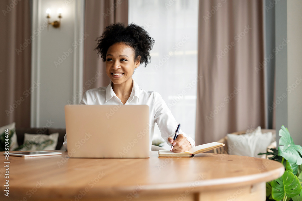 Student online training is a contented young curly-haired woman using a computer, sitting at a workplace at home. Courses in online education via a social network. Student online training is a contented young curly-haired woman using a computer, sitting at a workplace at home. Courses in online education via a social network.
