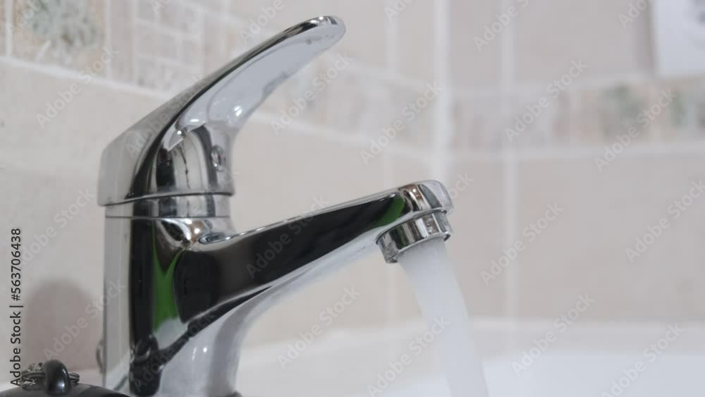 4k vídeo. Agua del grifo del cuarto de baño corriendo de forma poco sostenible. Despilfarro de agua