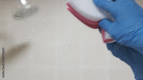 4k vídeo. Mujer de la limpieza trabajadora limpiando los cristales del cuarto de baño  photo