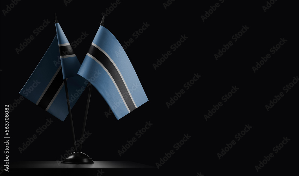 Small national flags of the Botswana on a black background