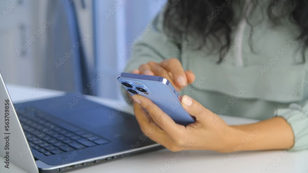 BIPOC female browsing mobile app on smart phone. Hands of POC woman using modern blue mobile phone for networking with clients BIPOC female browsing mobile app on smart phone. Hands of POC woman using modern blue mobile phone for networking with clients
